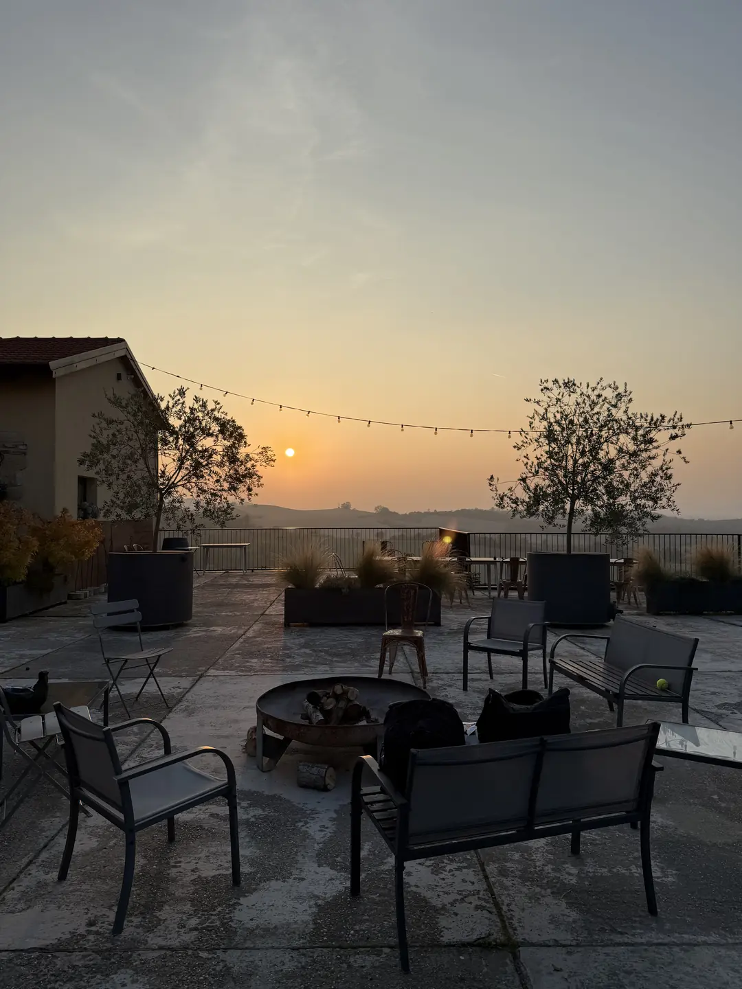 Terrazza al tramonto con luci e sedie, atmosfera raccolta
