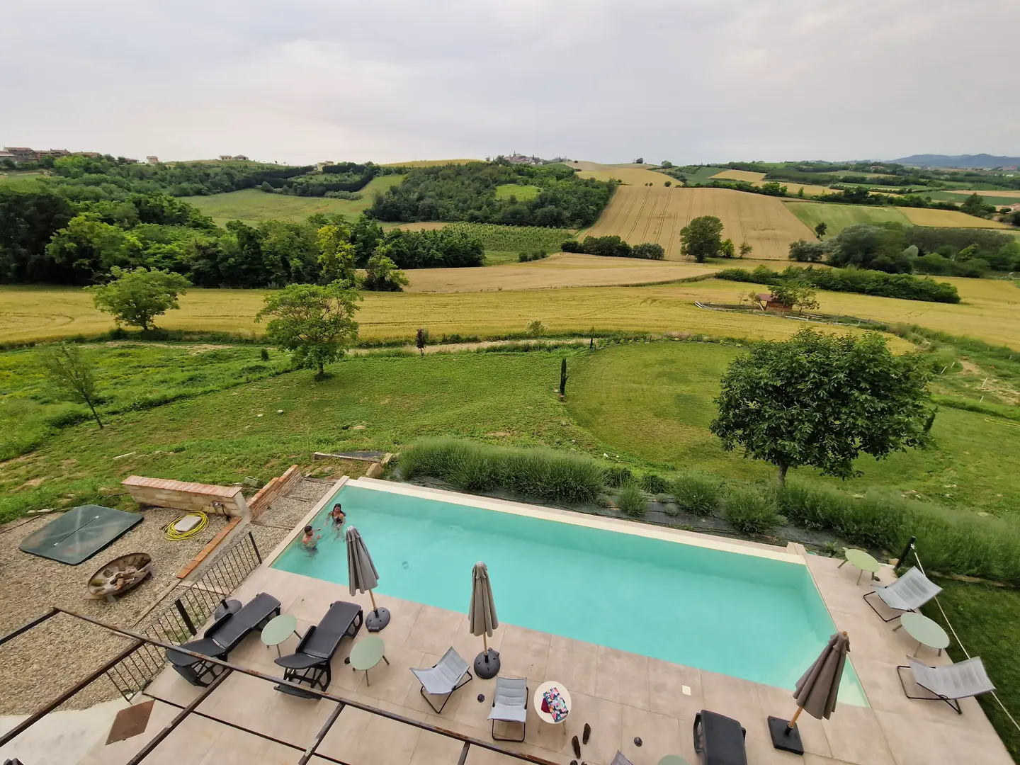 Piscina circondata da alberi e sedie, atmosfera rilassante